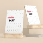 Two May desk calendars with a minimalist geometric pattern, displayed upright on light-colored wooden stand